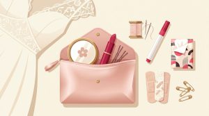 Una pochette rosa aperta e accessori per il matrimonio disposti su sfondo avorio.